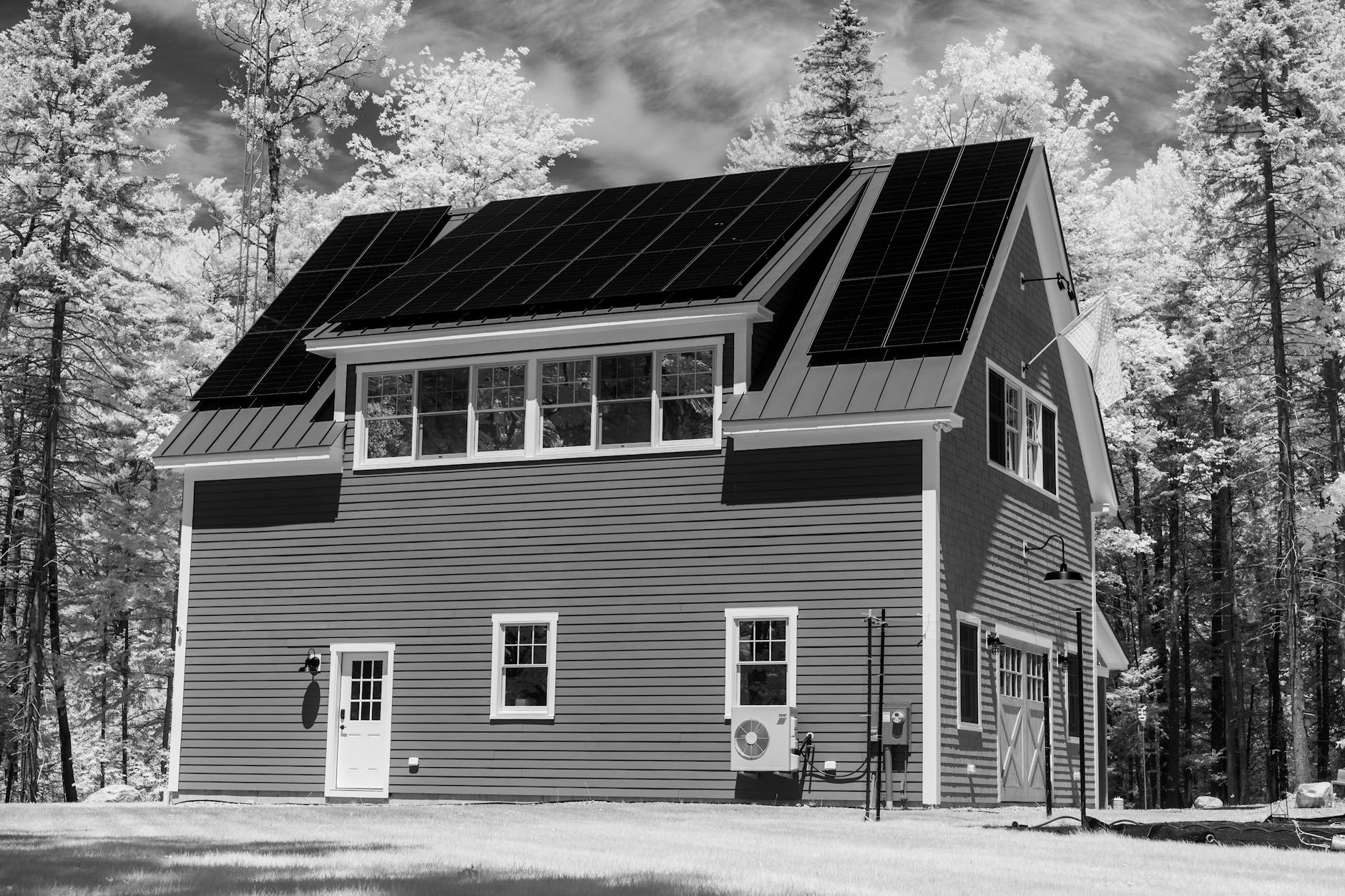 Moderner Schweizer Holzbau mit sichtbaren Balken und Lehmputzfassade vor alpiner Bergkulisse, Beispiel für nachhaltiges Bauen mit ökologischen Materialien.