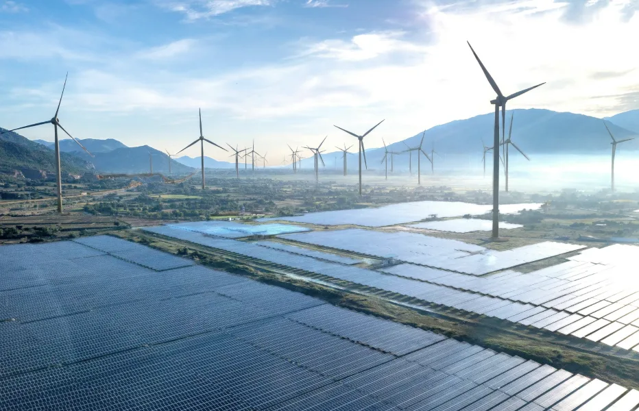 Ein Schweizer Einfamilienhaus während der energetischen Sanierung mit sichtbarer Fassadendämmung und neuen Fenstern, vor einer alpinen Landschaft.