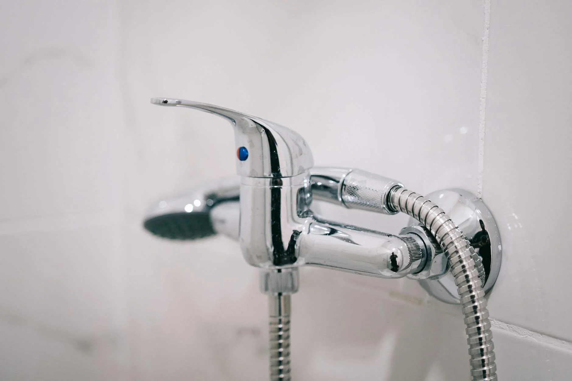 Ein modernes, helles Badezimmer in der Schweiz mit einer bodenebenen Dusche, mattschwarzen Armaturen und eleganten Holzregalen.