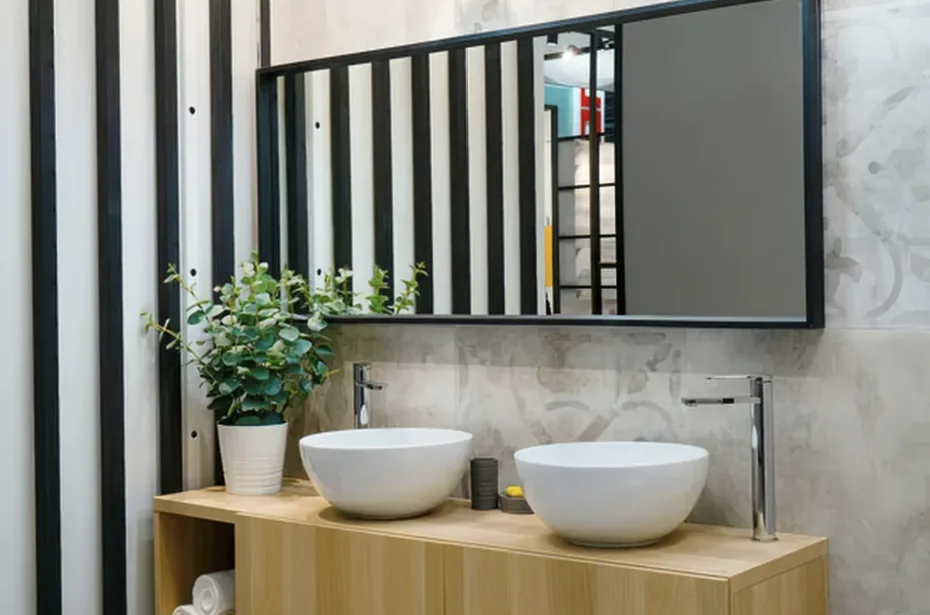 Ein modernes, helles Badezimmer in der Schweiz mit einer bodenebenen Dusche, mattschwarzen Armaturen und eleganten Holzregalen.