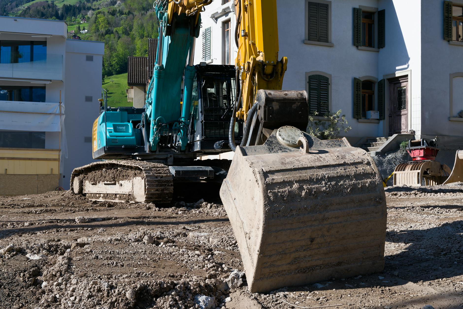 Ein Schweizer Bauprojekt im Entstehen mit Architekten und Bauherren, die Vertragsunterlagen auf einer Baustelle besprechen