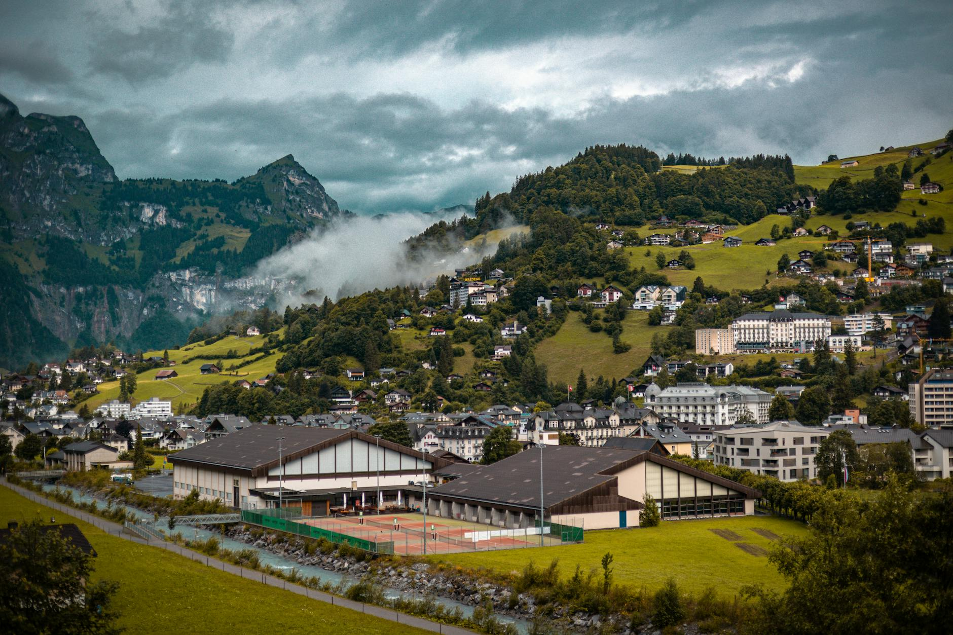 Ein Schweizer Bauprojekt im Entstehen mit Architekten und Bauherren, die Vertragsunterlagen auf einer Baustelle besprechen