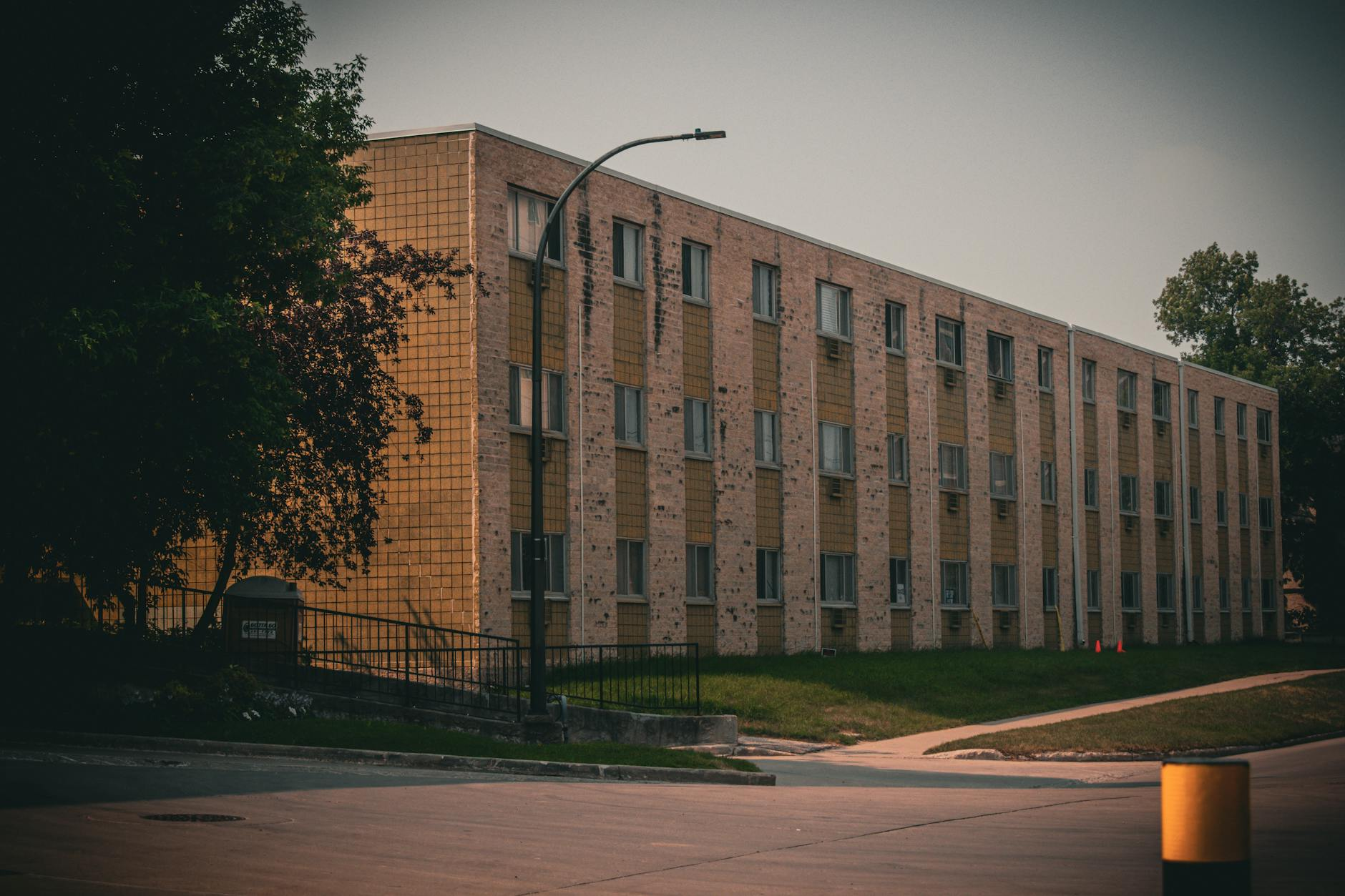 Ein typisches Schweizer Einfamilienhaus aus den 1950er Jahren mit Flachdach und Backsteinfassade, das für eine Sanierung vorbereitet wird, um Energieeffizienz und Modernität zu verbessern.